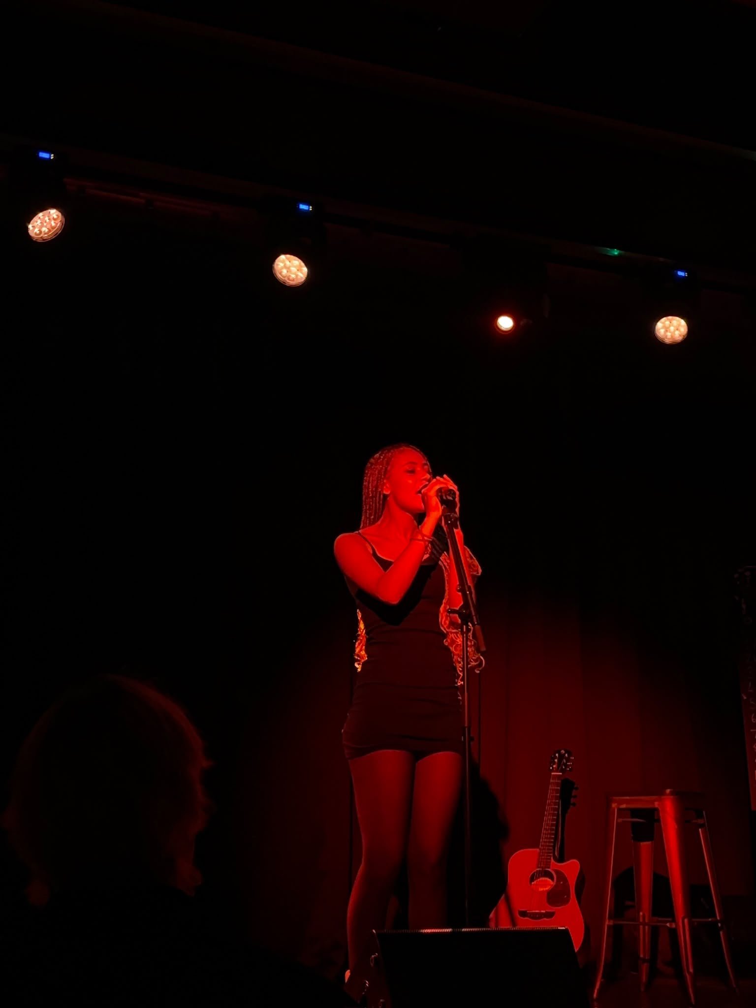 Lytoya Ri singing under red stage lights